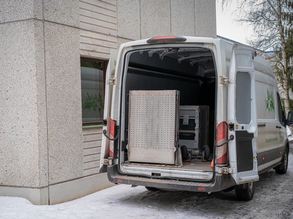 Geöffneter Transporter beim Beladen mit Möbeln vor einem Wohnhaus